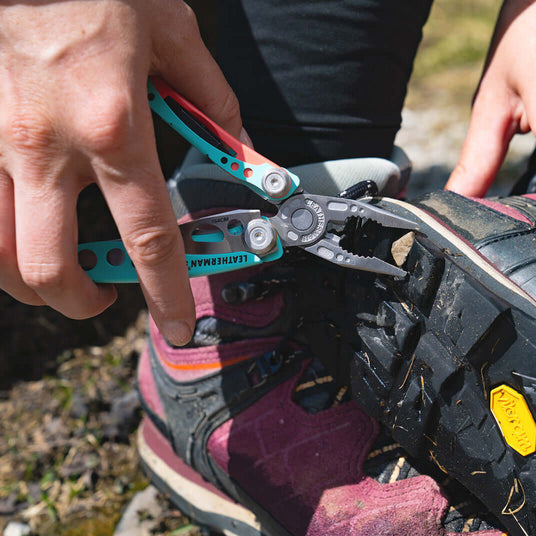 Translation missing: fr.Leatherman Skeletool CX pliers used to remove a stone stuck in the sole of a hiking boot