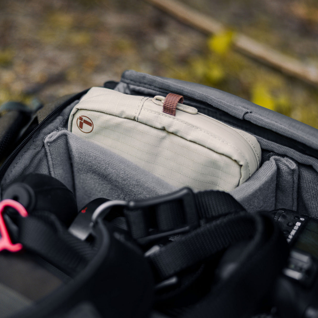 Translation missing: nl.A Leatherman Tool Pouch in Mossy Fog color is neatly packed inside a camera gear backpack, surrounded by padded compartments and photography equipment, highlighting the pouch’s portability and organizational fit for on-the-go adventures