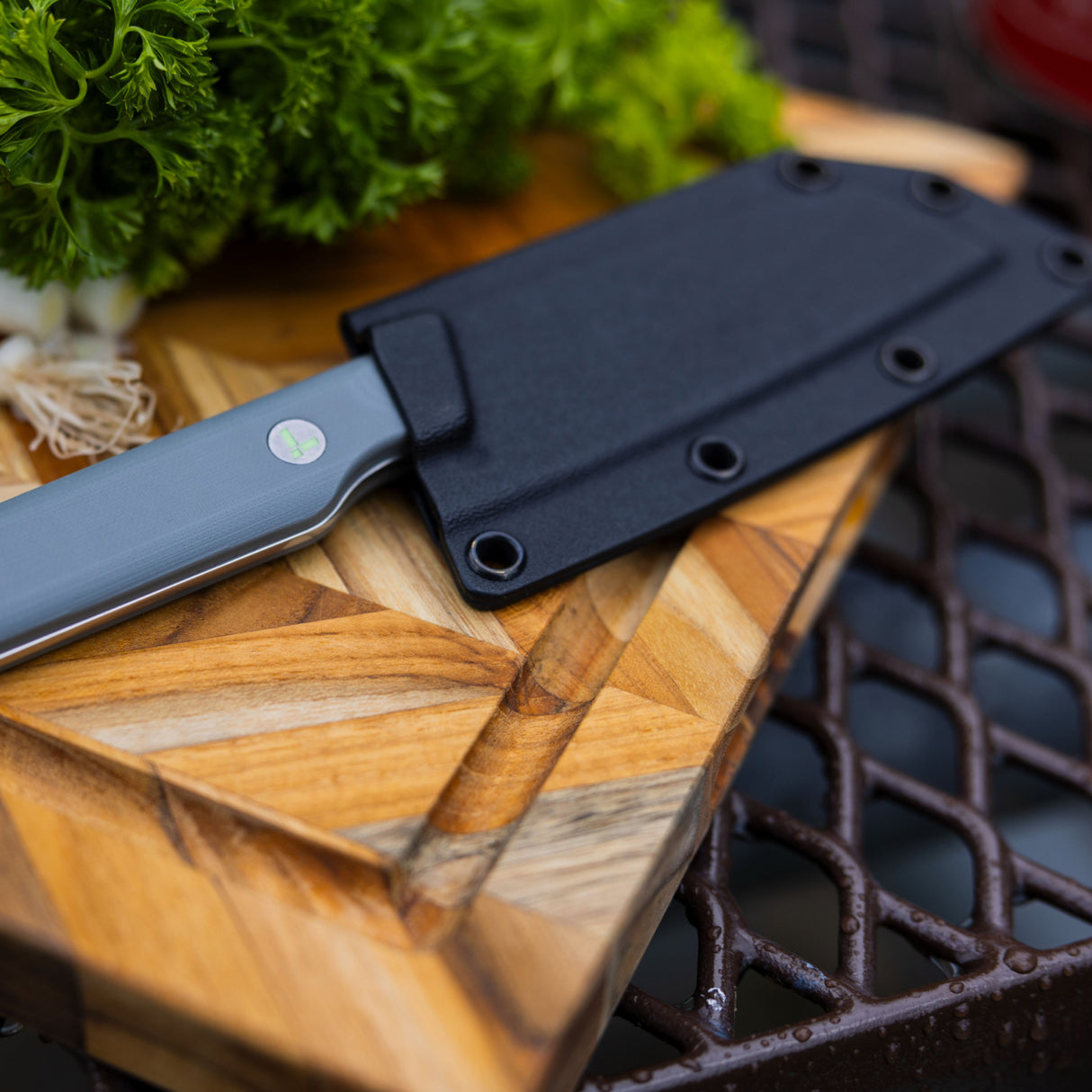 Translation missing: es.Leatherman Rustle in sheath placed on a cutting board alongside a selection of vibrant vegetables, indicating meal preparation