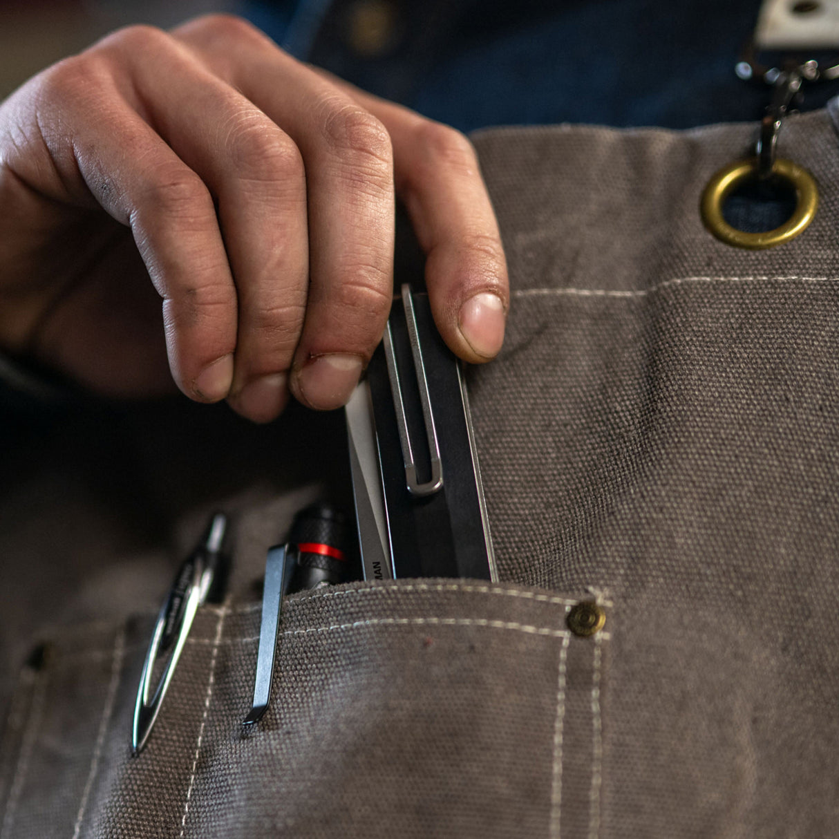 Translation missing: de.A person holds a pen and Leatherman Glider knife in their pocket, suggesting readiness for writing and potential utility tasks