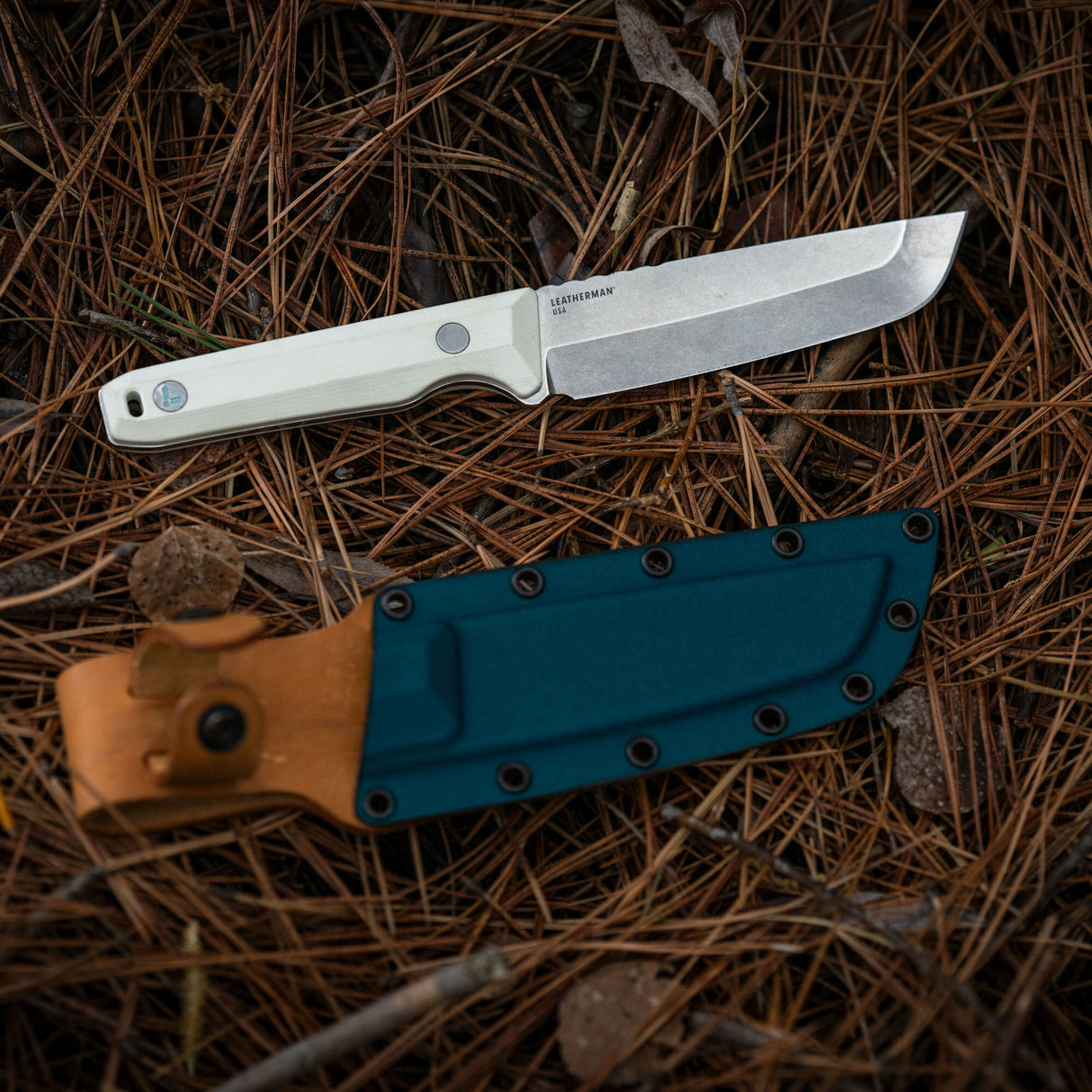 Translation missing: fr.Leatherman Alpine Pioneer knife displayed alongside its leather sheath, showcasing the blade and protective cover in a neutral setting