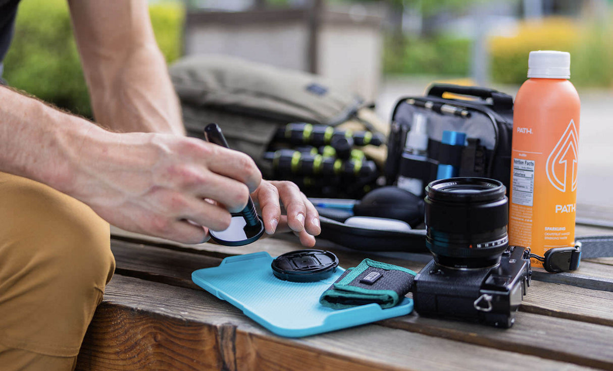 Translation missing: fr.Man using Leatherman® Adapt Kit tray to clean camera lens