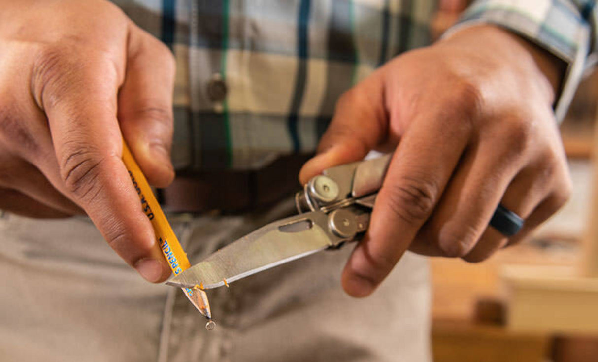 Translation missing: fr.Man using knife blade on Leatherman Curl to sharpen yellow pencil