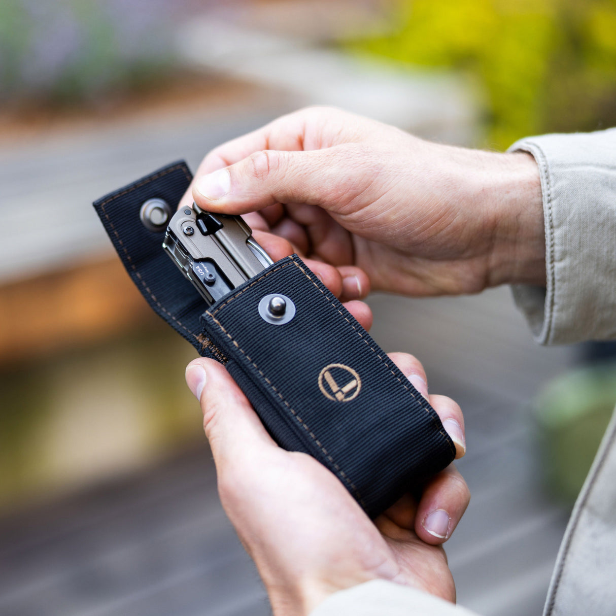 Translation missing: de.A hand pulls a Leatherman ARC Talos from a Black Bronze Nylon Sheath, showcasing how easy it is to access your multi-tool anytime you need it