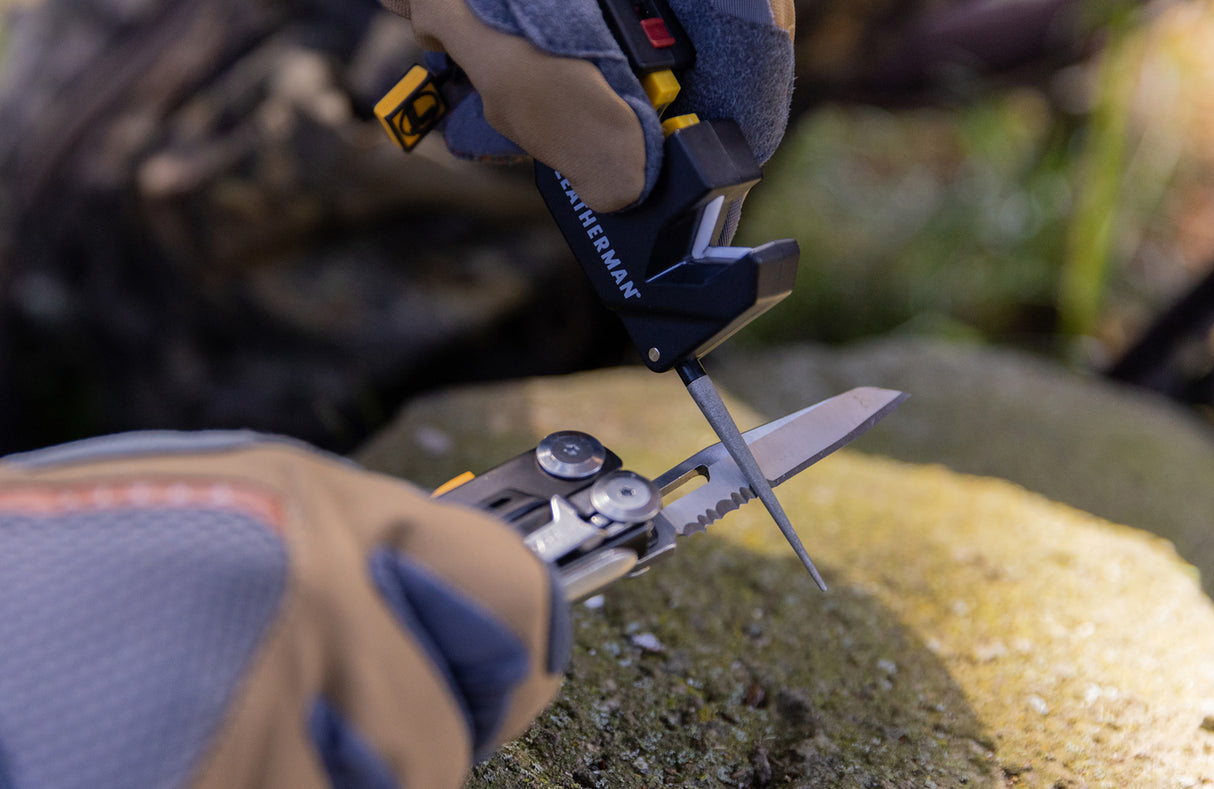 Translation missing: de.Man using Leatherman blade sharpener to sharpen Leatherman Signal