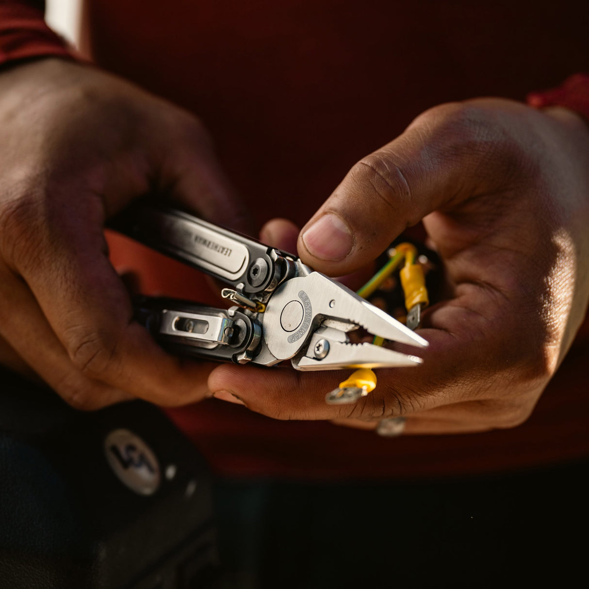 Translation missing: es.Person cutting rope with a Black DLC stainless steel Leatherman ARC® in a grassy outdoor setting