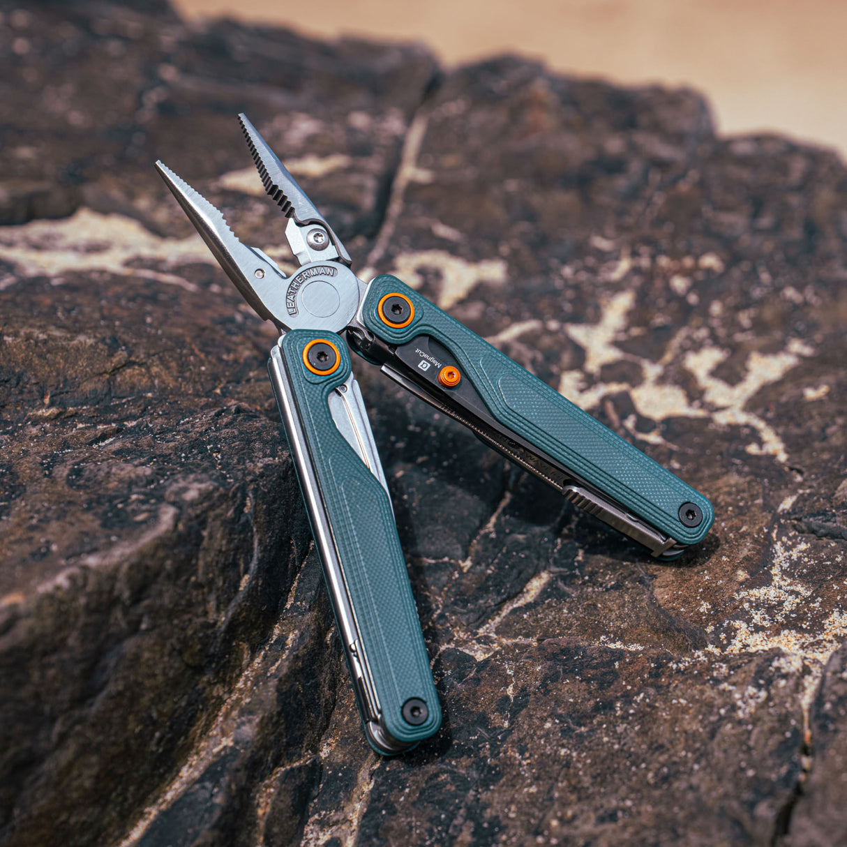 Translation missing: fr.Cascadia Leatherman Wave® Alpha multi-tool opened on a rock surface, showcasing its sleek design and pliers