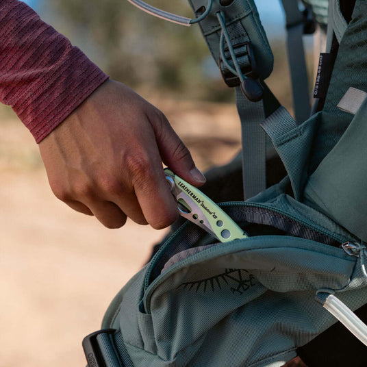 Translation missing: de.Person putting a closed Skeletool KB into a backpack