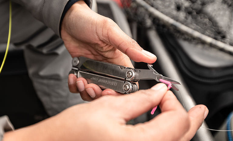 Translation missing: de.Man using scissors on Leatherman Curl to cut string
