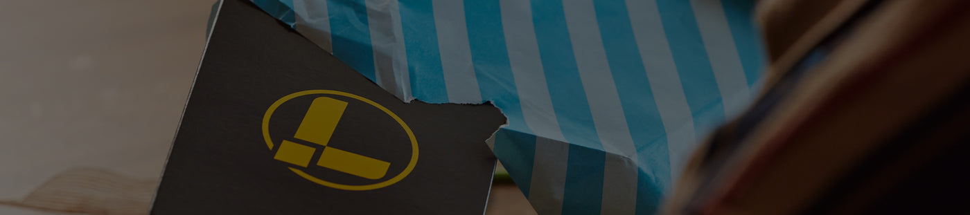 Translation missing: nl.A man unwraps a present containing a Leatherman box