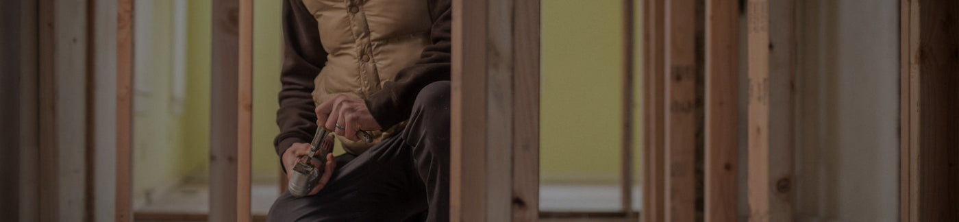 Translation missing: en.A man in a jacket is actively engaged in work at a construction site, surrounded by tools and equipment