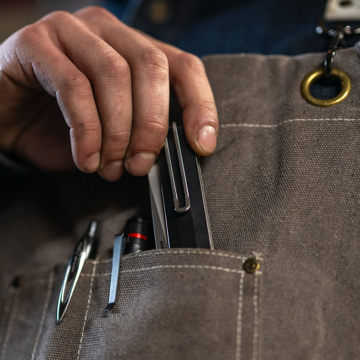 Translation missing: es.A person holds a pen and Leatherman Glider knife in their pocket, suggesting readiness for writing and potential utility tasks