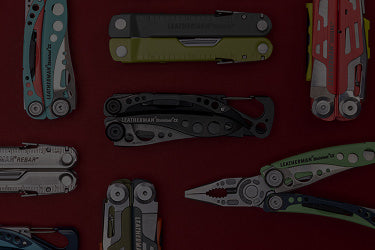 Translation missing: de.A variety of Leatherman tools in different styles are arranged on a vibrant red surface
