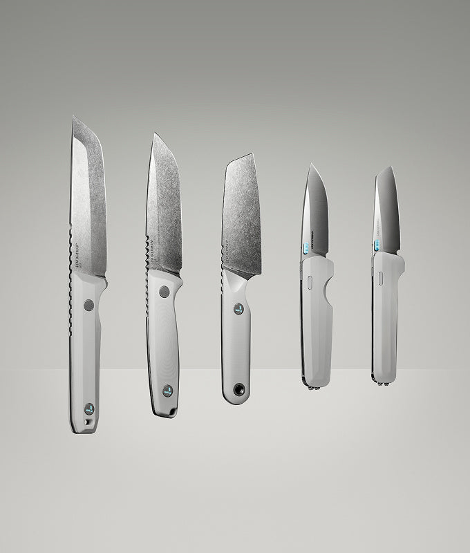 Translation missing: nl.Product display image featuring five Leatherman knives in a clean, gradient-lit studio setting. The lineup includes various blade styles and handle orientations, all in a matching alpine white colorway, showcasing both profile and edge-on views to highlight the craftsmanship and design variations