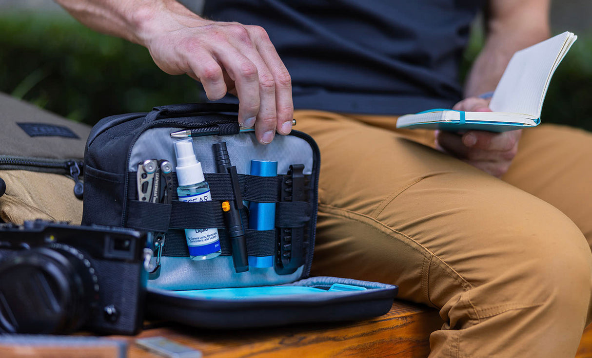 Translation missing: pl.Man pulling pen from Leatherman® Adapt Kit to write on notepad