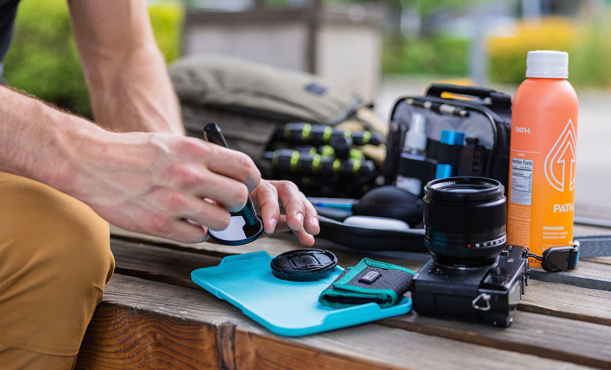 Translation missing: pl.Man using Leatherman® Adapt Kit tray to clean camera lens