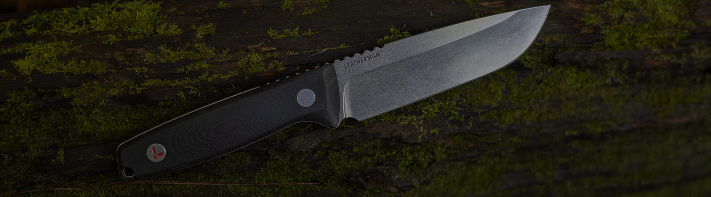 Translation missing: nl.Leatherman Trac in soft focus, placed on a mossy log, showing off the state of the art Magnacut steel blade and g10 handle