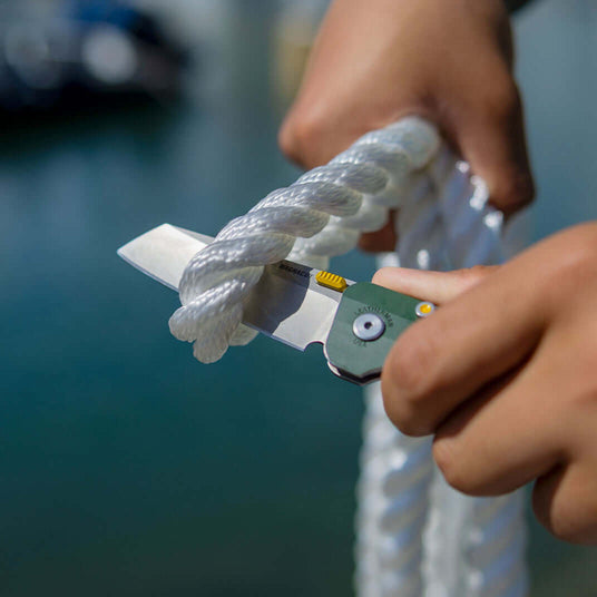 Translation missing: es.Evergreen Leatherman Glider being used on a dock to cut thick, white, mooring rope