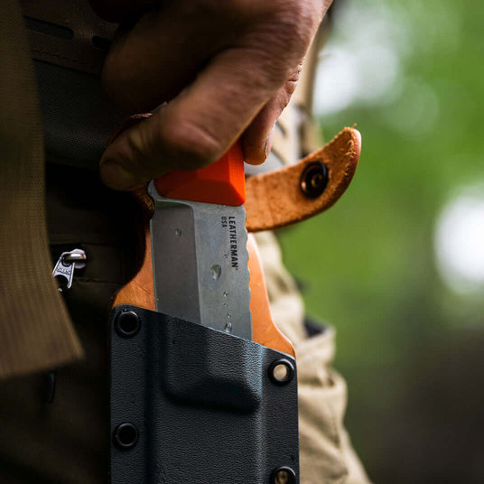 Translation missing: es.Orange Pop Leatherman Pioneer showing off the bright orange G10 handle being pulled from a premium sheath