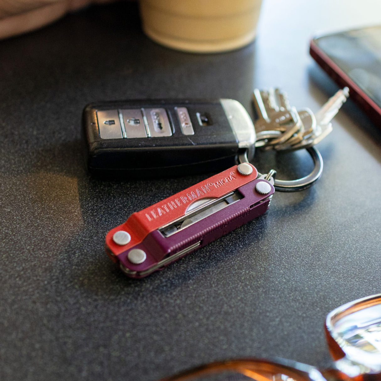 Translation missing: fr.A Mulled Wine Leatherman Micra® attached to a keyring with car keys resting on a dark tabletop