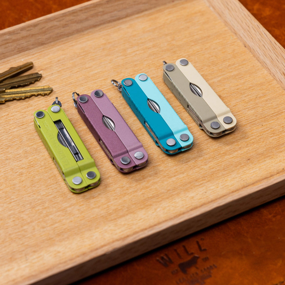 Translation missing: es.Four Leatherman Micra® in various colors displayed on a vanity tray next to keys