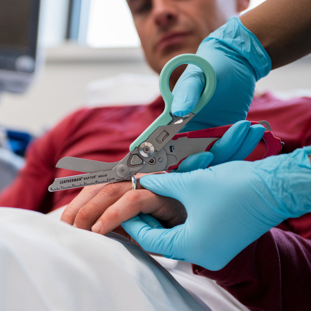Translation missing: en.Person using the ring cutter on a South Beach Leatherman Raptor® Rescue to cut a ring off a finger
