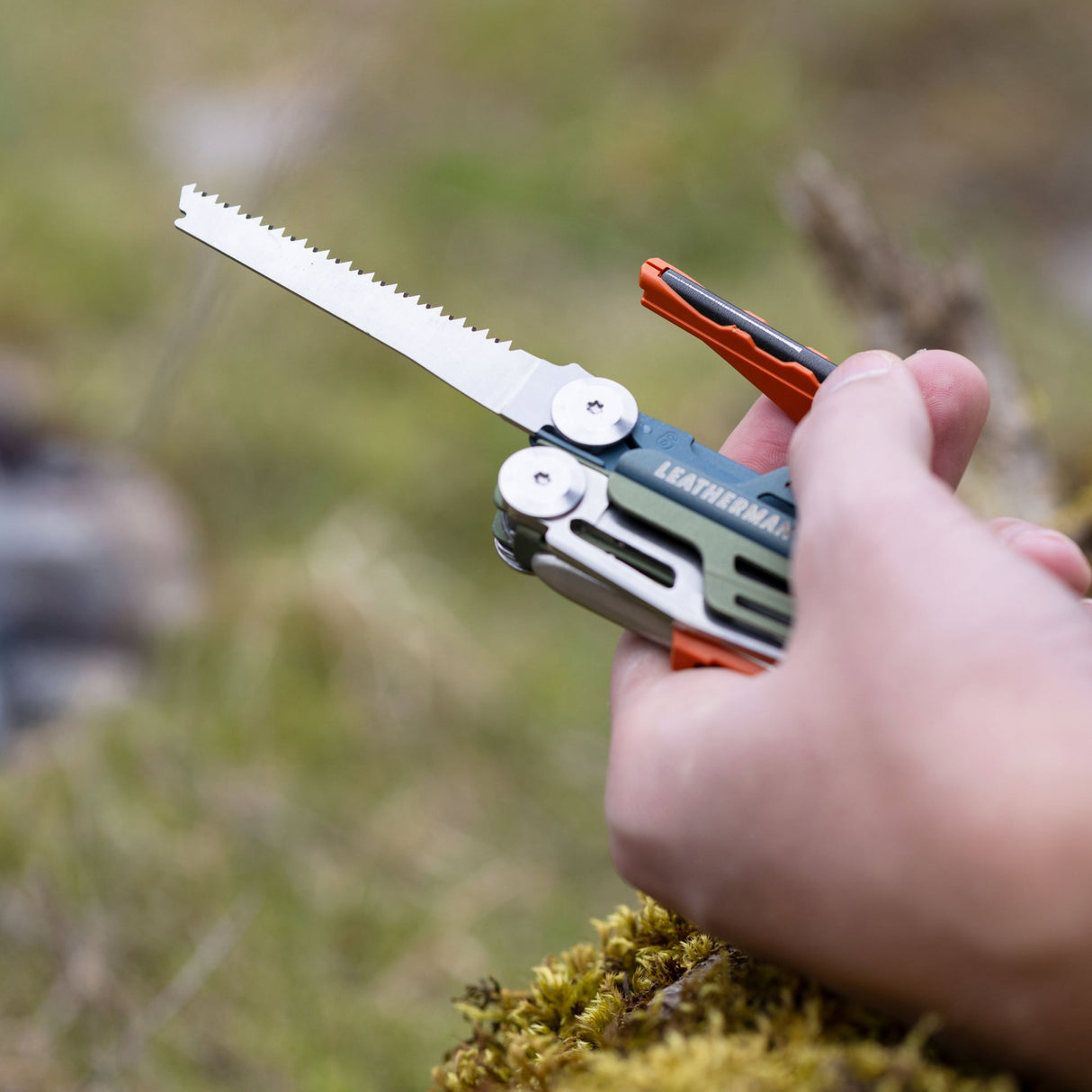 Translation missing: es.A close-up of a person’s hand clutching a Tundrascape Leatherman Signal®, ready to use the fire starter and saw