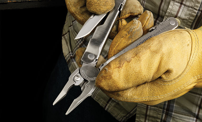 Translation missing: es.Man in green plaid shirt and yellow leather gloves pulling knife blade out of Leatherman Super Tool 300