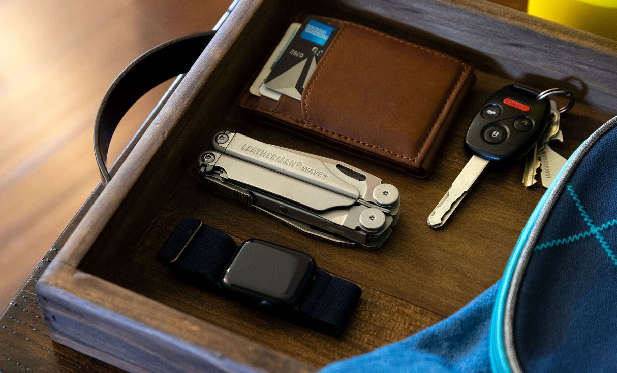 Translation missing: es.Stainless Steel Leatherman Wave® Plus multi-tool in a wooden vanity with wallet, keys, and smartwatch