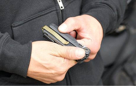 Translation missing: fr.Person holding an Obsidian Leatherman Wave® Alpha multi-tool, showcasing the Brass PVD Quick-Release pocket clip