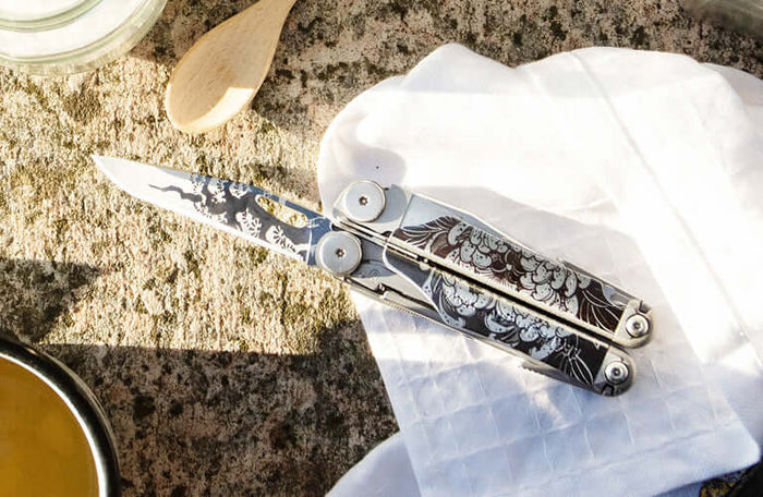 Translation missing: pl.Wave® Plus multi-tool with intricate floral design on a stone surface surrounded by kitchenware