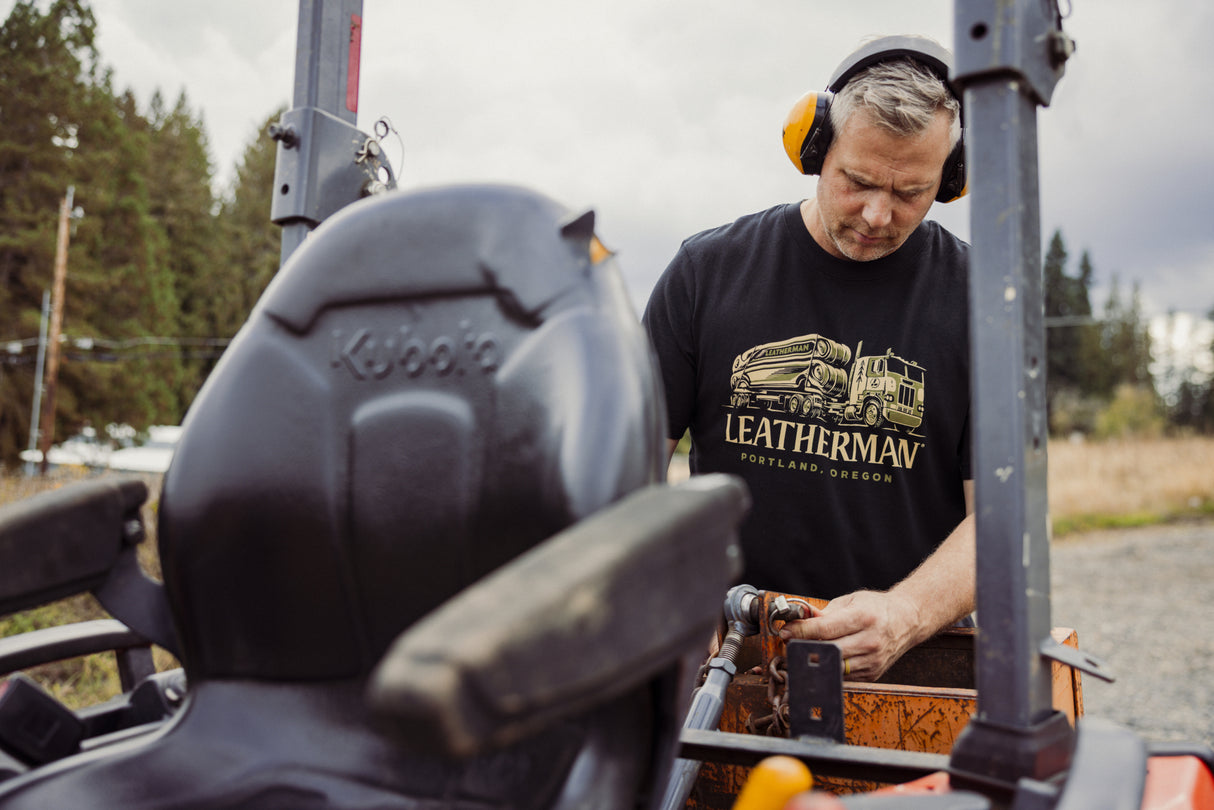 Translation missing: fr.A person wearing a black Leatherman Timber Tee working on a tractor outdoors