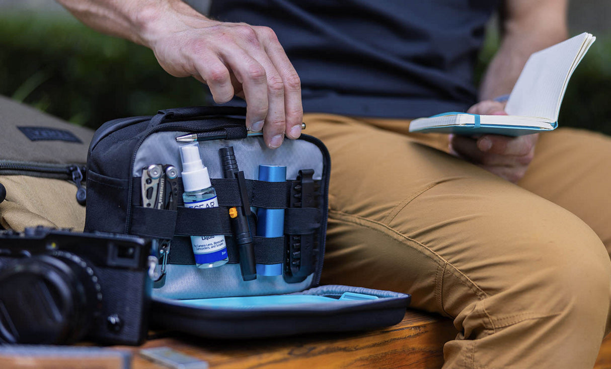 Man pulling pen from Leatherman® Adapt Kit to write on notepad 