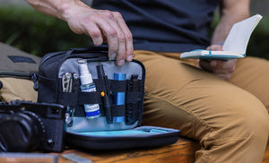 Man pulling pen from Leatherman® Adapt Kit to write on notepad 