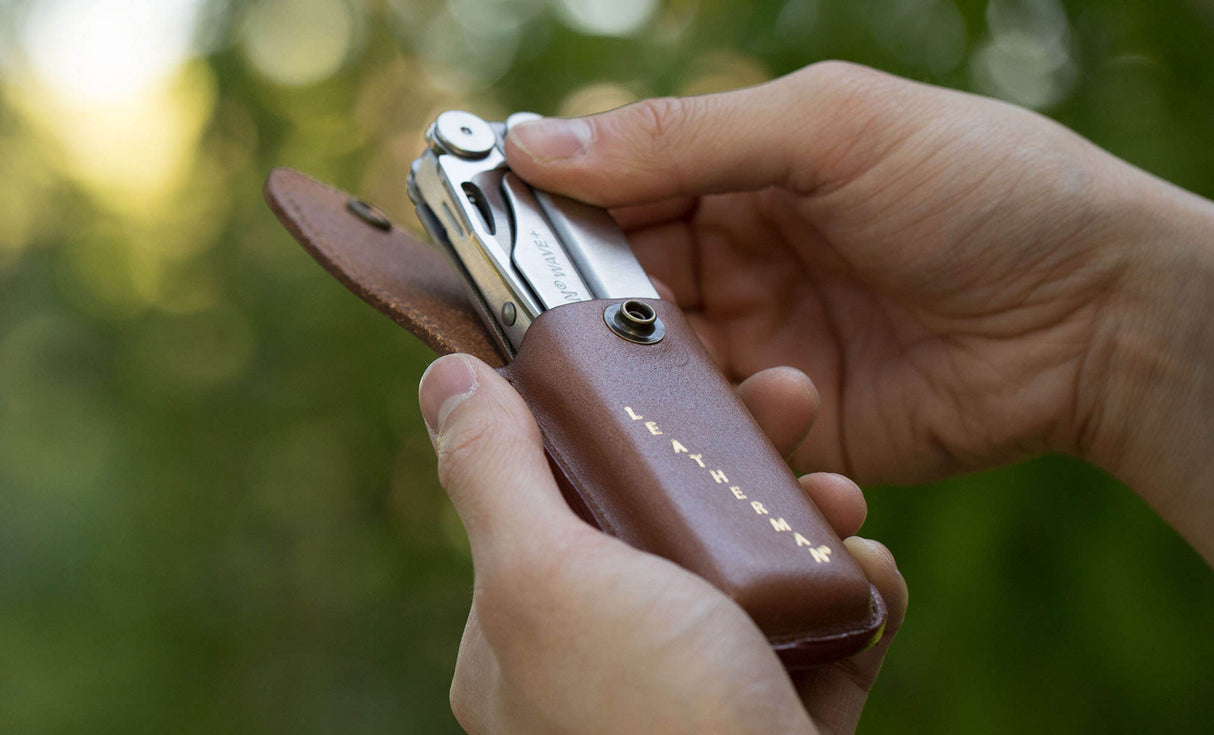 Man pulling Leatherman Wave+ out of Leatherman Heritage Sheath 