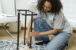 Translation missing: en.A person wearing a gray Leatherman Classic Tee using a Wave Alpha in Cascadia color to assemble a small table in a bright indoor setting