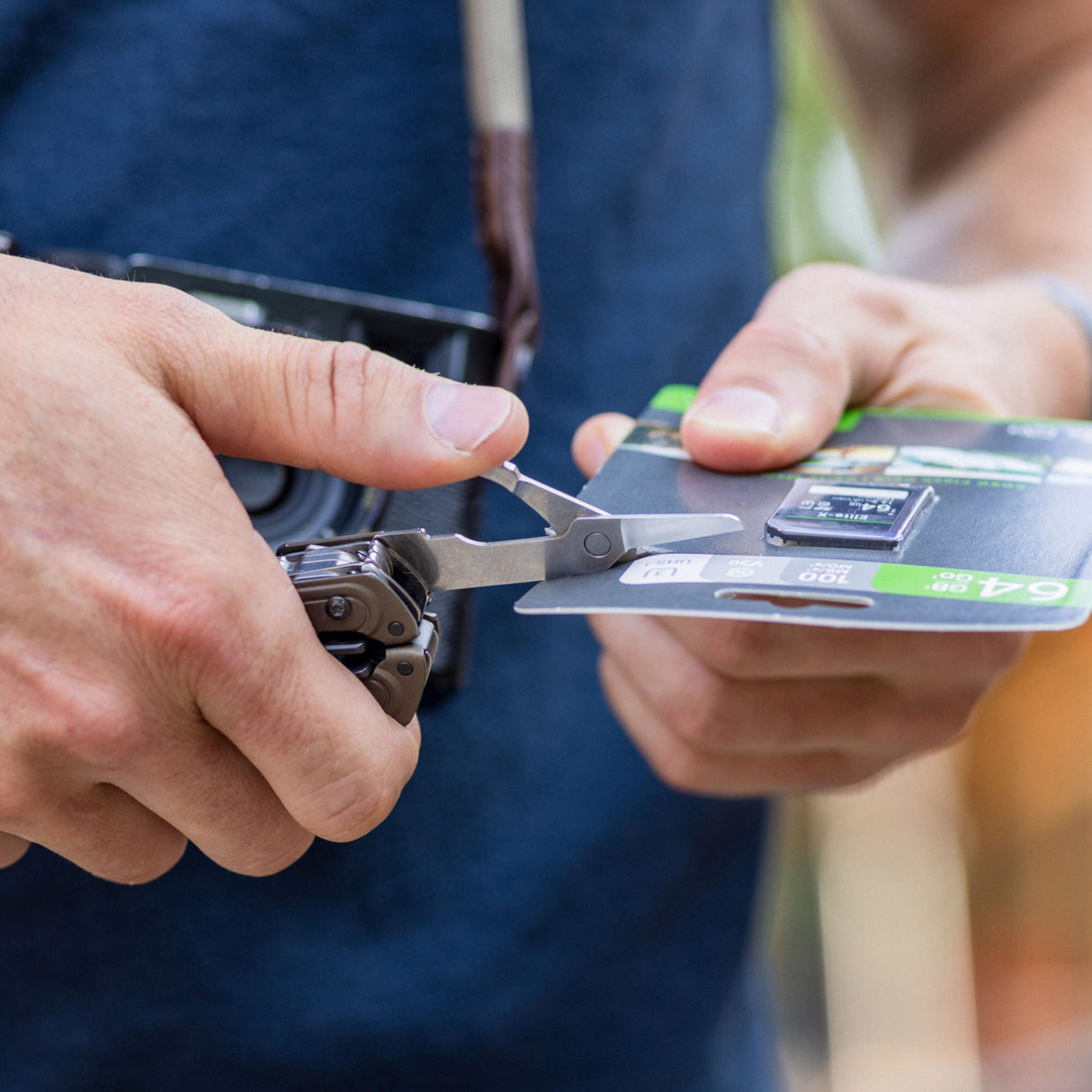 Translation missing: de.ARC Talos one-hand access scissors being used to open SD card packaging