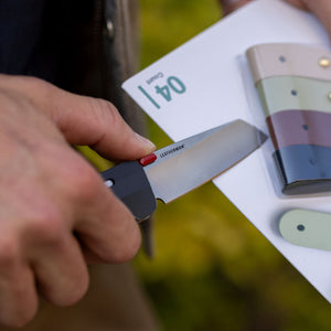 Translation missing: en.A person holds a knife and a knife sharpener, ready to open a package