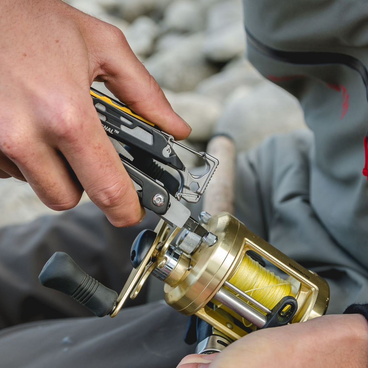 Translation missing: de.A person uses Leatherman Singal to secure a fishing reel, demonstrating a unique fishing technique