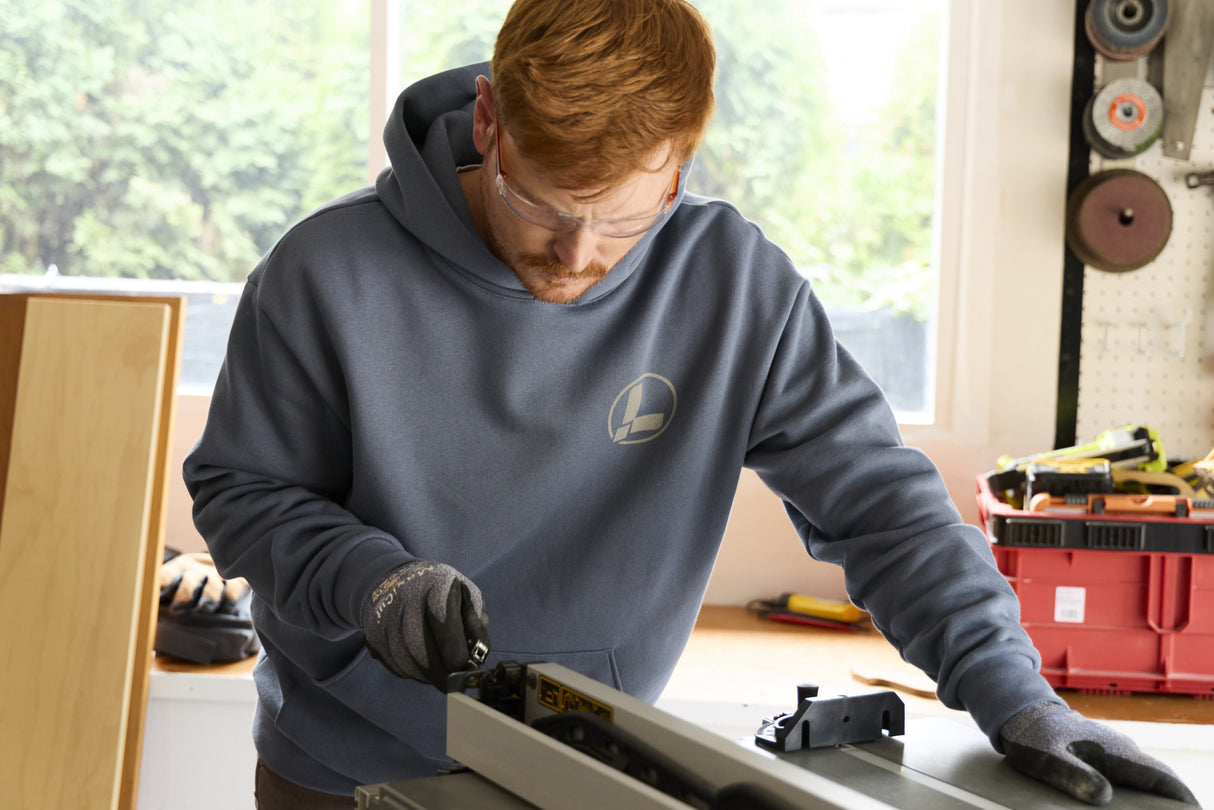 Translation missing: en.A person wearing a storm blue Leatherman Classic Hoodie working in a bright workshop