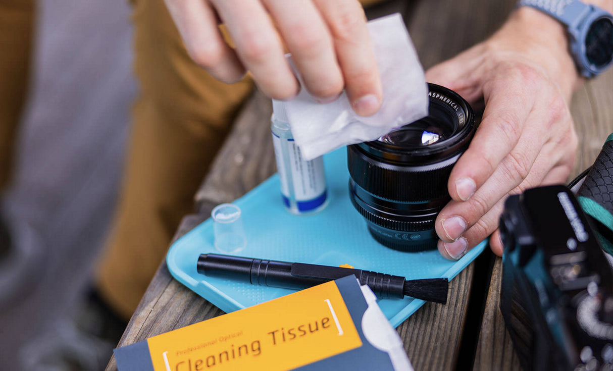 Man using Leatherman® Adapt Kit tray to clean camera lens 