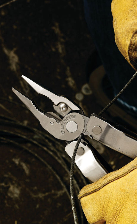 A Leatherman being used to cut a wire.