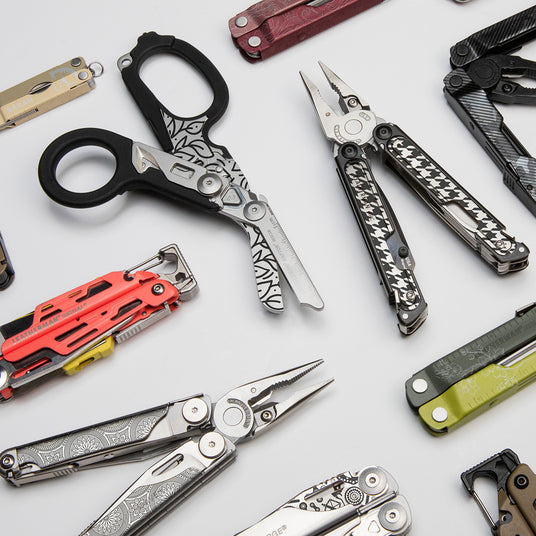 An assortment of Leatherman multi-tools arranged on a table, highlighting their diverse shapes and features.