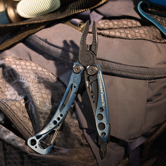 Translation missing: da.Nocturnal Leatherman Skeletool® Cx multi-tool displayed on a backpack, showcasing its sleek design and functionality