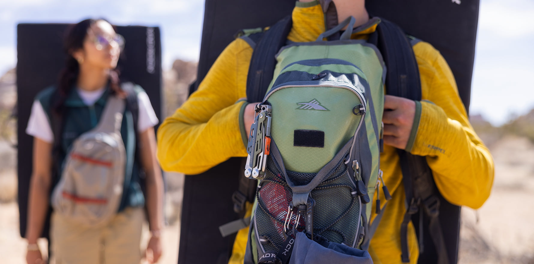 Signal® Tundrascape Limited Edition multitool clipped to the strap of a hiker's green backpack