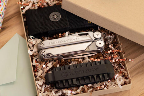 Translation missing: es.Leatherman Wave closed in a gift box next to a sheath and a bit kit on a table