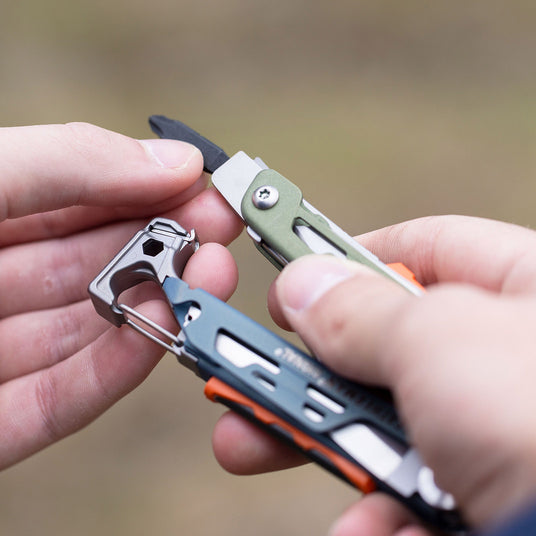 A close-up of a person’s hand holding a Leatherman Signal, emphasizing its practicality and utility.