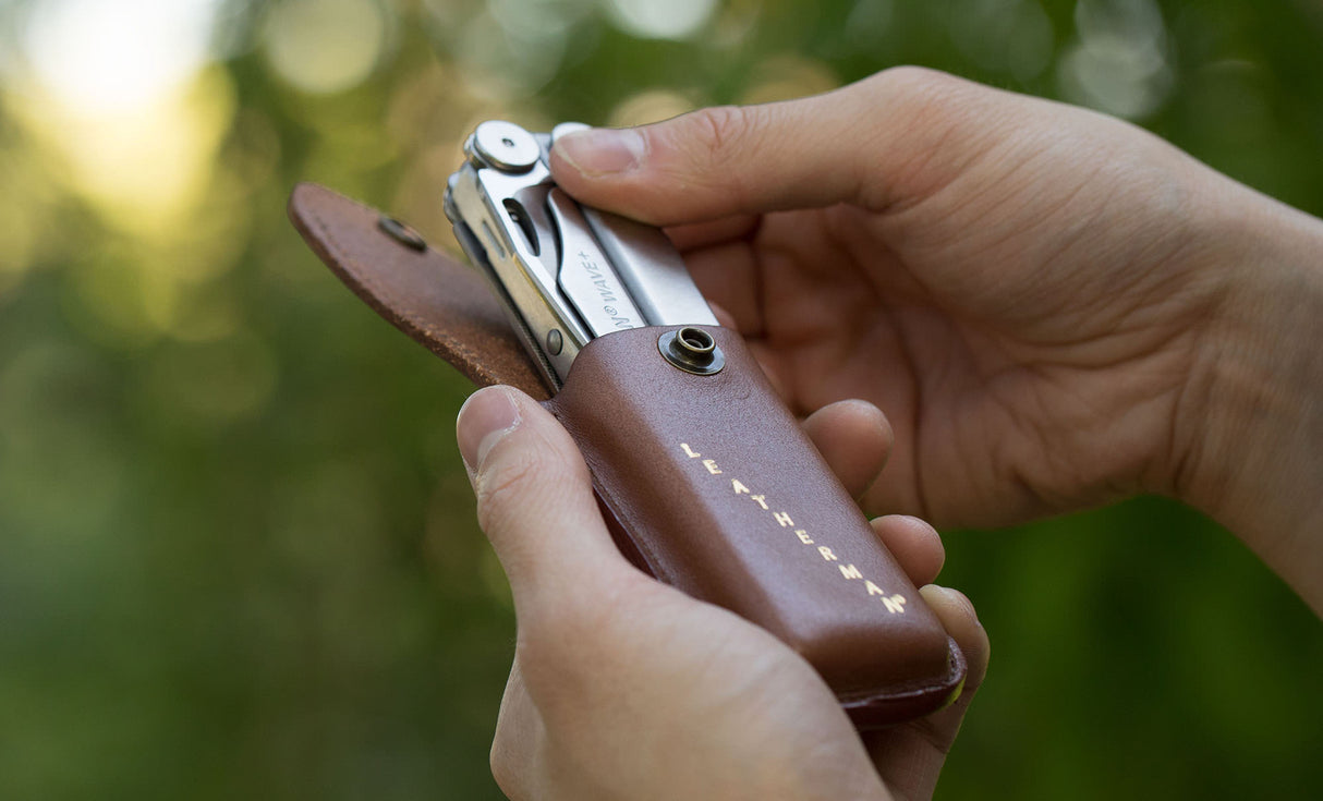 Translation missing: de.Man pulling Leatherman Wave+ out of Leatherman Heritage Sheath