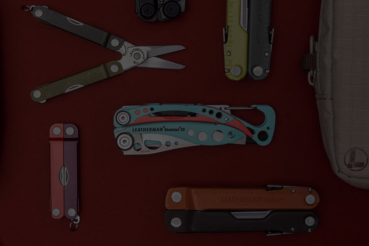 Translation missing: es.A variety of Leatherman tools in different styles are arranged on a vibrant red surface