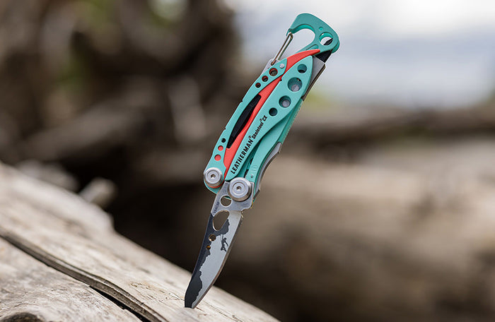Translation missing: nl.Leatherman Skeletool CX inserted in wooden surface, showcasing their metallic finish against the natural wood grain